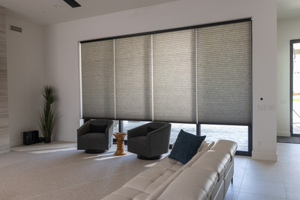Cellular shades blocking heat and glare on large living room windows